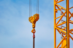 Yellow construction crane against blue sky